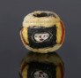 Ancient mosaic glass bead with face pattern